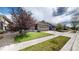 Charming single-Gathering home with a well-maintained lawn, mature tree, and two-car garage at 15402 E 113Th Pl, Commerce City, CO 80022