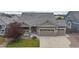 Attractive home with a three-car garage, stone accents, and a well-manicured front lawn at 15402 E 113Th Pl, Commerce City, CO 80022