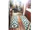 Hallway with decorative wood floors and patterned rugs leading to a living room, showcasing stylish transition between spaces at 9115 W 2Nd Ave, Lakewood, CO 80226