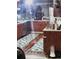 Kitchen with stainless steel appliances, dark cabinets, stainless countertop, and patterned rugs on wood floors at 9115 W 2Nd Ave, Lakewood, CO 80226