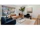 Living room with light brown couch, dark blue chairs, and large window at 936 Eudora St # 102, Denver, CO 80220