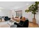 Living room with tan couch, dark blue chairs, and large window at 936 Eudora St # 102, Denver, CO 80220