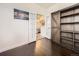 Bedroom with wooden floors leading into a bathroom with double doors at 12941 Lafayette St # E, Thornton, CO 80241