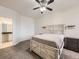 Bright main bedroom featuring a ceiling fan, carpeted floors, and an ensuite bathroom at 12941 Lafayette St # E, Thornton, CO 80241