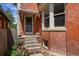 Charming brick home with a cozy front porch, steps leading to the entry, and a small landscaped garden at 187 S Pearl St, Denver, CO 80209