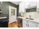 Compact kitchen with white cabinets, stainless steel appliances, and easy access to the outside at 187 S Pearl St, Denver, CO 80209