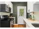 Well-lit kitchen with modern appliances, white cabinetry, and a convenient layout at 187 S Pearl St, Denver, CO 80209