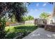 A backyard with mature trees, a trampoline, a deck, a greenhouse, and raised planter beds at 1115 Cherry Ct, Fort Lupton, CO 80621
