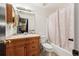 Bathroom with wood vanity, framed mirror, and shower-tub combination at 1115 Cherry Ct, Fort Lupton, CO 80621