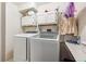 A laundry room with a washer, dryer, overhead cabinets, and a folding table at 1115 Cherry Ct, Fort Lupton, CO 80621