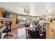 Spacious living room featuring a brick fireplace, hardwood flooring, and backyard views at 1115 Cherry Ct, Fort Lupton, CO 80621