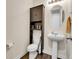 Half-bath features pedestal sink, toilet and cabinet storage at 9844 Truckee St, Commerce City, CO 80022