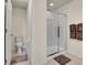 Compact bathroom featuring a modern toilet, a glass-enclosed shower, and towel racks for added convenience at 9844 Truckee St, Commerce City, CO 80022