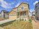 Beautiful two-story house with tan siding, a two-car garage, and well-maintained front yard at 9844 Truckee St, Commerce City, CO 80022