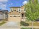 Charming two-story home with tan siding, a two-car garage, and well-manicured landscaping at 9844 Truckee St, Commerce City, CO 80022