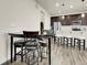 Open concept eat-in kitchen boasts stainless appliances, dark cabinetry, and bar seating at 9844 Truckee St, Commerce City, CO 80022