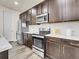 Updated kitchen showcasing stainless steel appliances, modern cabinetry, and sleek countertops at 9844 Truckee St, Commerce City, CO 80022