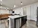 Kitchen island with stainless steel appliances, dark cabinetry and bar seating at 9844 Truckee St, Commerce City, CO 80022