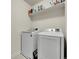 Bright laundry room with modern washer and dryer, complemented by ample shelf space for storage solutions at 9844 Truckee St, Commerce City, CO 80022
