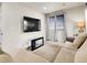 Bright loft space featuring a plush sectional, mounted TV, and windows with modern blinds and curtains at 9844 Truckee St, Commerce City, CO 80022