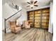 Comfortable living room with hardwood floors, built-in bookshelves, and a staircase at 9844 Truckee St, Commerce City, CO 80022
