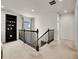 Upstairs loft with natural light, staircase access, and a stylish built-in bookshelf, offering a versatile living space at 9844 Truckee St, Commerce City, CO 80022