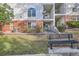 Building featuring multiple balconies and a manicured lawn with bench at 1878 S Cole St, Lakewood, CO 80228