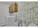 Bright laundry room with overhead storage, a laundry rack and delightful leaf-patterned wallpaper at 8755 Chase Dr # 167, Arvada, CO 80003