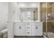Bathroom with dual sinks, a large mirror, and glass-enclosed shower at 3282 N Catawba Way, Aurora, CO 80019