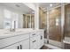 Bathroom featuring dual vanity, shower with glass door, and modern finishes at 3282 N Catawba Way, Aurora, CO 80019