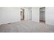 Bedroom featuring neutral carpet, closet, and view into the ensuite bathroom at 3282 N Catawba Way, Aurora, CO 80019