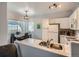 Bright kitchen with white cabinets and appliances, open to a dining area with a large window at 5455 S Dover St # 101, Littleton, CO 80123