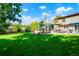 Beautiful backyard with lush green grass, mature trees, patio, and inviting outdoor seating areas at 7344 S Sheephorn Mtn, Littleton, CO 80127