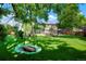 Spacious backyard featuring a swing, lush lawn, and a view of the home's exterior at 7344 S Sheephorn Mtn, Littleton, CO 80127