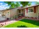 Inviting front entrance featuring lush green lawn, lovely landscaping and a charming covered porch at 7344 S Sheephorn Mtn, Littleton, CO 80127