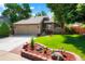 Charming home featuring a well-manicured lawn, lovely landscaping, and a two-car garage, all under a bright blue sky at 7344 S Sheephorn Mtn, Littleton, CO 80127