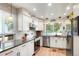 Bright kitchen featuring white cabinets, stainless steel appliances, and modern lighting at 7344 S Sheephorn Mtn, Littleton, CO 80127