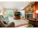 Comfortable living room featuring a stone fireplace, sliding glass doors to the patio, and cozy seating at 7344 S Sheephorn Mtn, Littleton, CO 80127