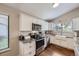 Charming kitchen features white cabinets, stainless steel appliances, granite countertops, and hardwood floors at 7830 W 90Th Ave # 67, Broomfield, CO 80021