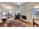 Cozy living room with hardwood floors, stone fireplace, and open access to the adjacent kitchen at 7830 W 90Th Ave # 67, Broomfield, CO 80021