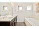 Bathroom featuring double sinks, a soaking tub, and modern finishes at 4330 N Raleigh St, Denver, CO 80212