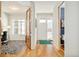 Inviting foyer featuring hardwood floors with a green rug, and a view into an office space with zebra patterned rug at 4330 N Raleigh St, Denver, CO 80212