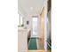 Bright hallway with a door to the outside and a sliding wooden door with a green runner rug on tile flooring at 4330 N Raleigh St, Denver, CO 80212