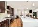 Modern kitchen featuring stainless appliances, dark wood cabinetry, an island, and hardwood floors in an open concept living space at 4330 N Raleigh St, Denver, CO 80212