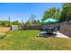 Spacious backyard featuring a table with umbrella and chair seating with ample green lawn at 3962 Hoyt Ct, Wheat Ridge, CO 80033