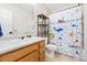 Charming bathroom features a wood vanity, a shower with a playful, nautical-themed curtain and a tiled floor at 3962 Hoyt Ct, Wheat Ridge, CO 80033
