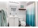Bathroom with wainscoting, classic white vanity, shower/tub with curtain, toilet, and framed mirror at 3962 Hoyt Ct, Wheat Ridge, CO 80033