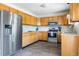 Bright kitchen with oak cabinets, granite countertops, stainless steel appliances, and tile backsplash at 3962 Hoyt Ct, Wheat Ridge, CO 80033