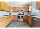 Bright kitchen with oak cabinets, granite countertops, stainless steel appliances, and tile backsplash at 3962 Hoyt Ct, Wheat Ridge, CO 80033