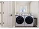 Modern laundry room equipped with front-load washer and dryer and white walls and door at 3962 Hoyt Ct, Wheat Ridge, CO 80033